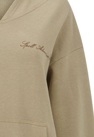 close-up-of-a-beige-sweatshirt-sleeve-with-a-small-brown-embroidered-script-logo-on-the-upper-chest-photographed-against-a-white-background